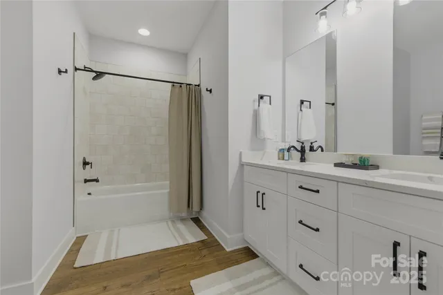 a bathroom with a tub sink shower and mirror