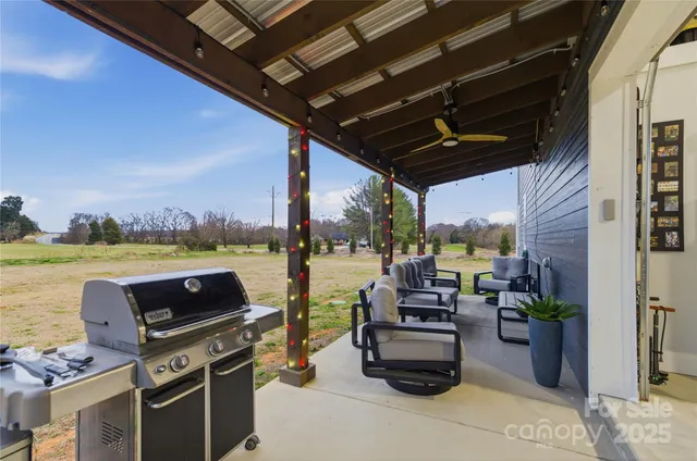 a view of a patio with couches potted plants and a kitchen