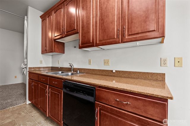 a view of a kitchen with stainless steel appliances granite countertop a sink dishwasher stove and cabinets