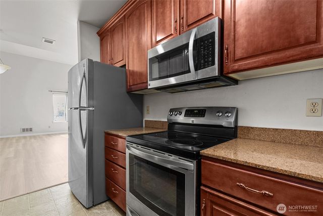 a kitchen with stainless steel appliances granite countertop a stove microwave and refrigerator