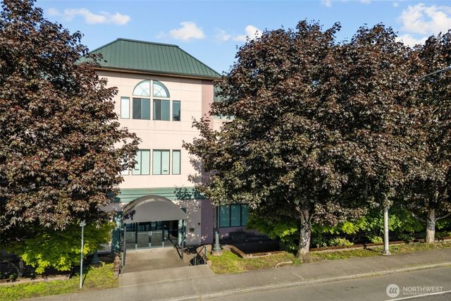 a front view of a house with a garden and trees
