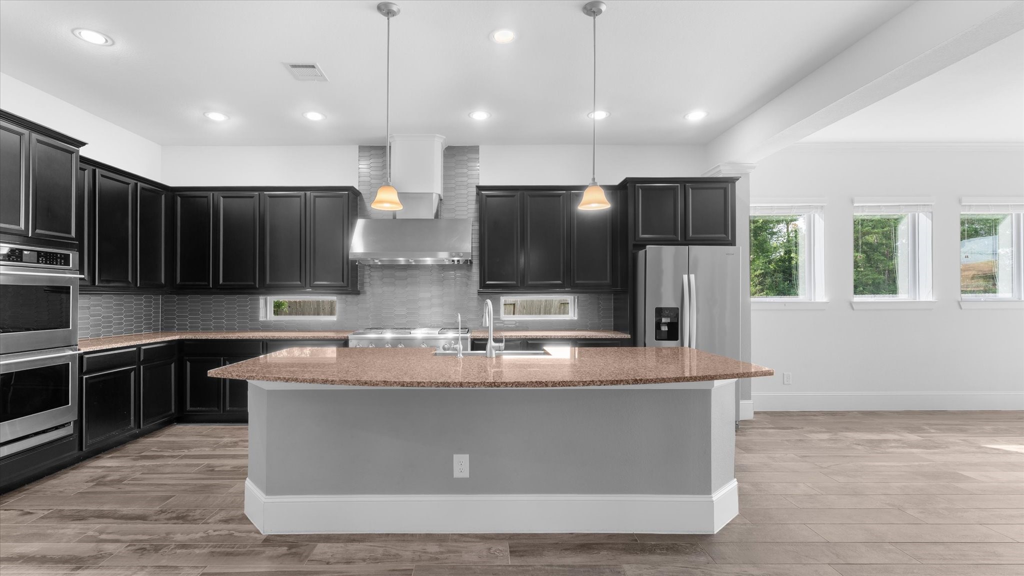 32001 Birch Briar Court Spring, TX 77386 - Photo 9 of 48 Bright open-concept living area seamlessly connecting the chef's kitchen, dining, and family room for effortless everyday living.
