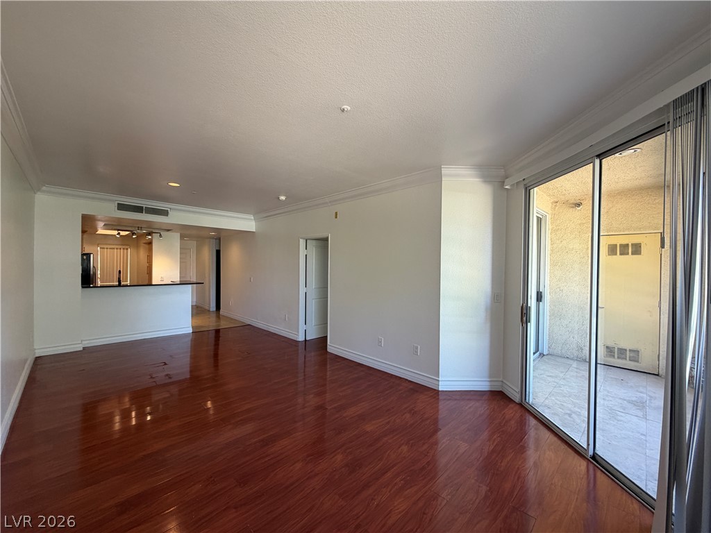 210 East Flamingo Road, Unit 126 Las Vegas, NV 89169 - Photo 6 of 16 Hardwood floors and a spacious layout enhance this inviting living area, flowing into a private balcony.