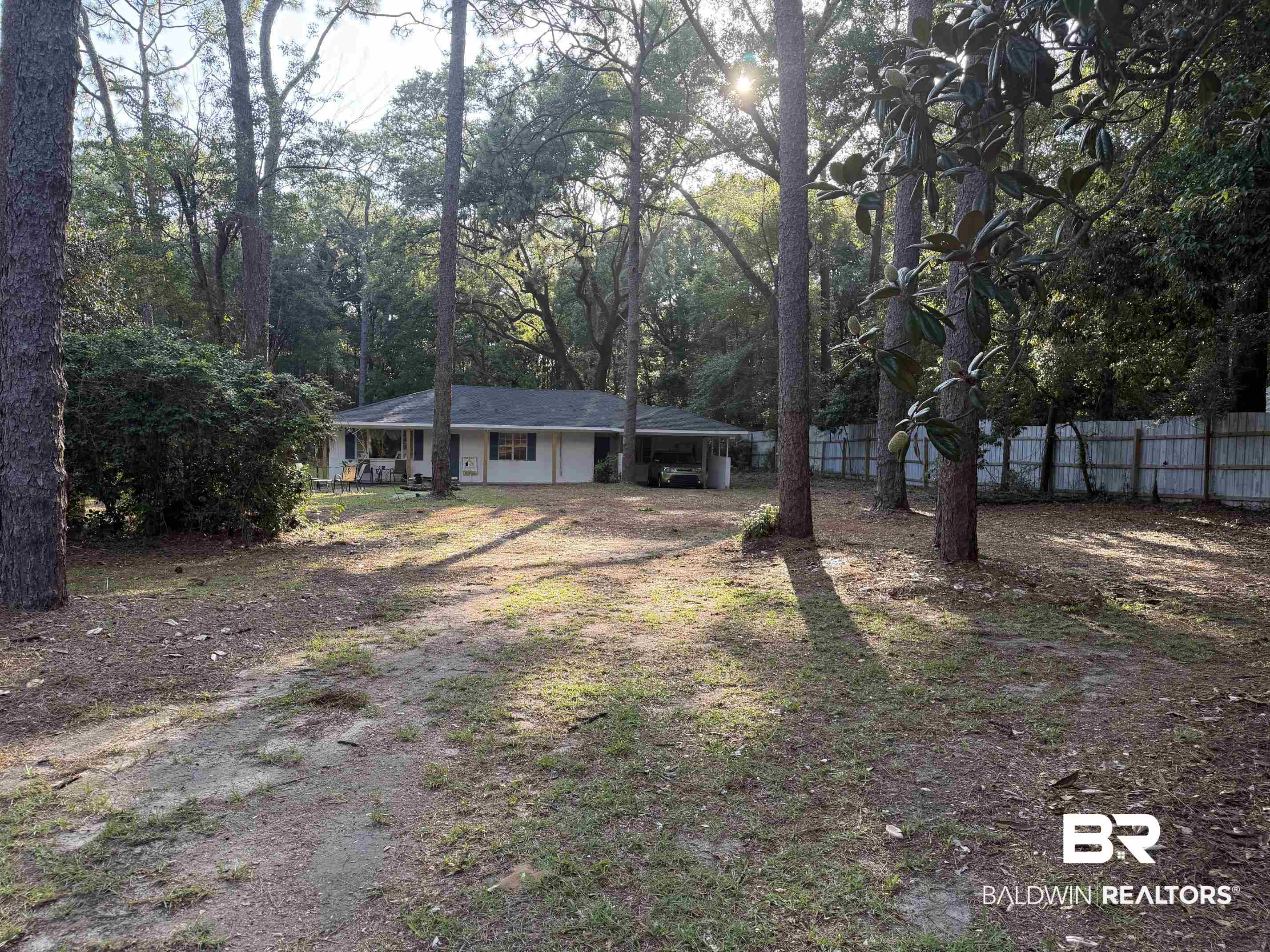 1401 East Forest Ridge Road Mobile, AL 36618 - Photo 2 of 19 Single-story residence set amidst mature trees, featuring a light-colored exterior and a dark-shingled roof