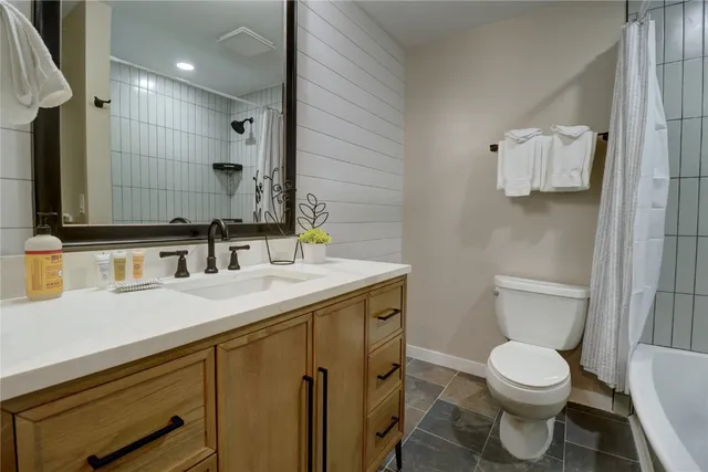 a bathroom with a sink a toilet and mirror
