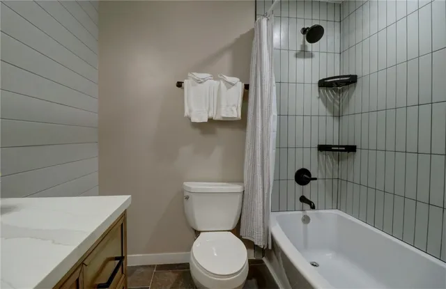 a white toilet sitting next to a bath tub and shower