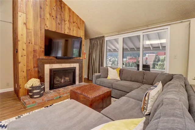 a living room with furniture a large window and a fireplace