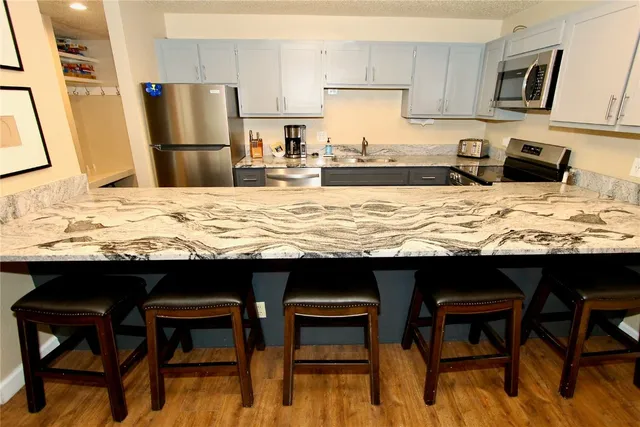 a kitchen with stainless steel appliances granite countertop wooden cabinets a stove top oven a sink and dishwasher