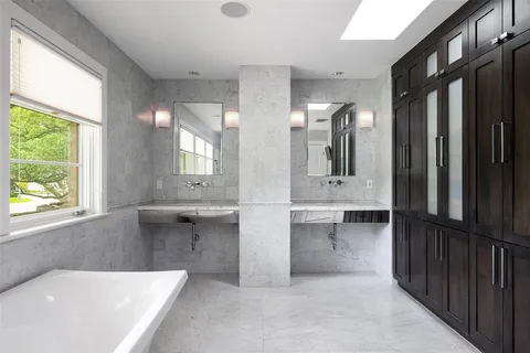 a bathroom with double vanity and a bathtub
