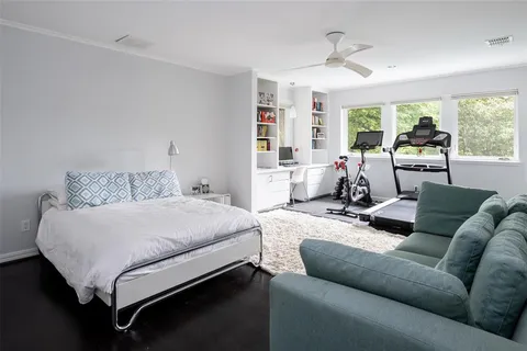 a bedroom with a bed couch and a large window
