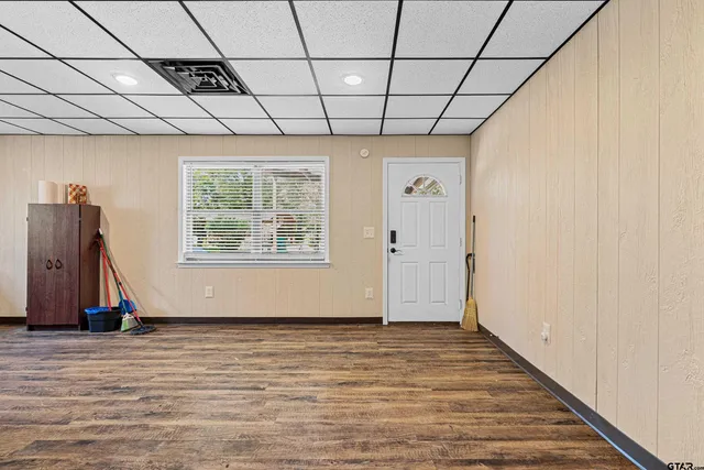 a view of a hallway with wooden floor and a cabinet