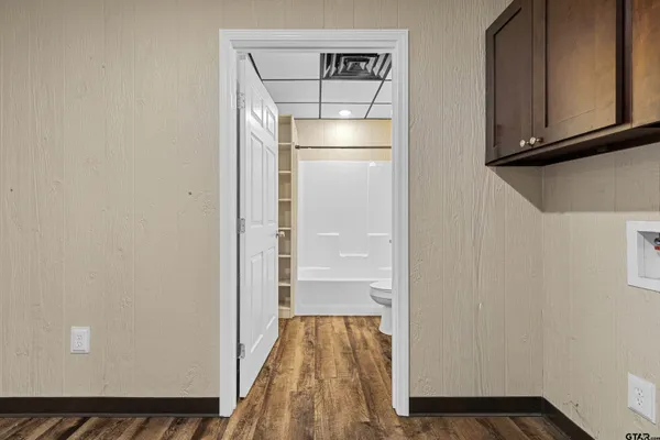 a kitchen with stainless steel appliances granite countertop a stove a sink dishwasher a dining table and chairs with wooden floor