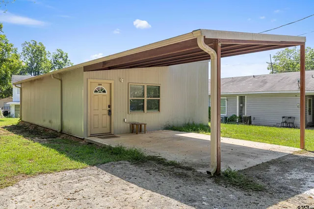 a backyard of a house with table and chairs