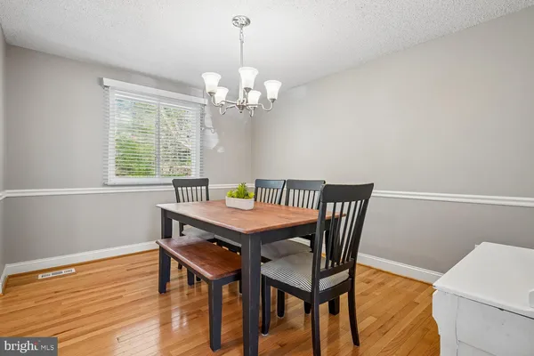 a view of a dining room with furniture a chandelier and wooden floor