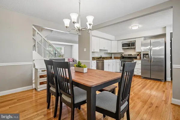 a view of a dining room with furniture a chandelier and wooden floor