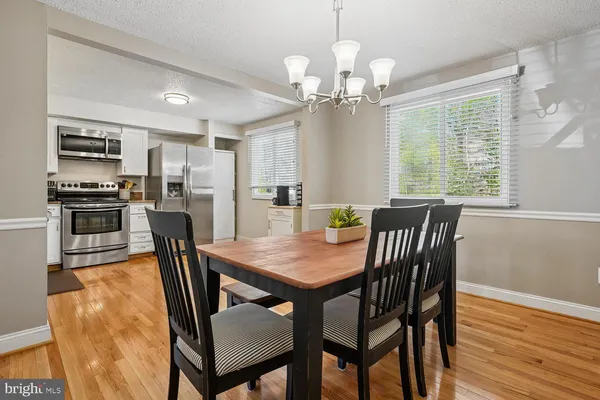a view of a dining room with furniture a chandelier and wooden floor