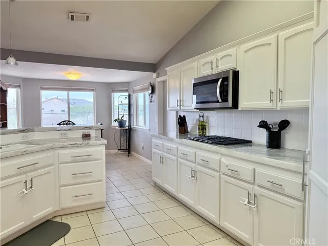 a living room with furniture a flat screen tv and kitchen view