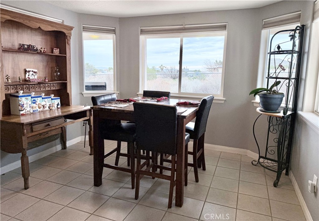 7915 Outpost Road Oak Hills, CA 92344 - Photo 14 of 54 a view of a dining room with furniture and a window