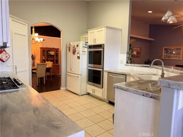 a kitchen with stainless steel appliances kitchen island granite countertop a sink and cabinets