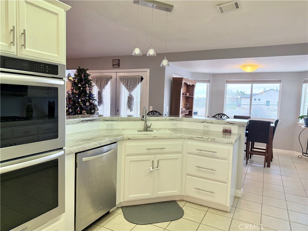 7915 Outpost Road Oak Hills, CA 92344 - Photo 19 of 54 a kitchen with a sink cabinets and window