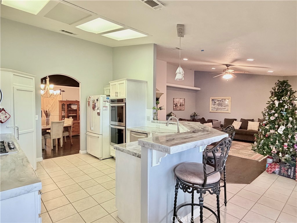 7915 Outpost Road Oak Hills, CA 92344 - Photo 20 of 54 a kitchen with stainless steel appliances kitchen island granite countertop a sink and cabinets