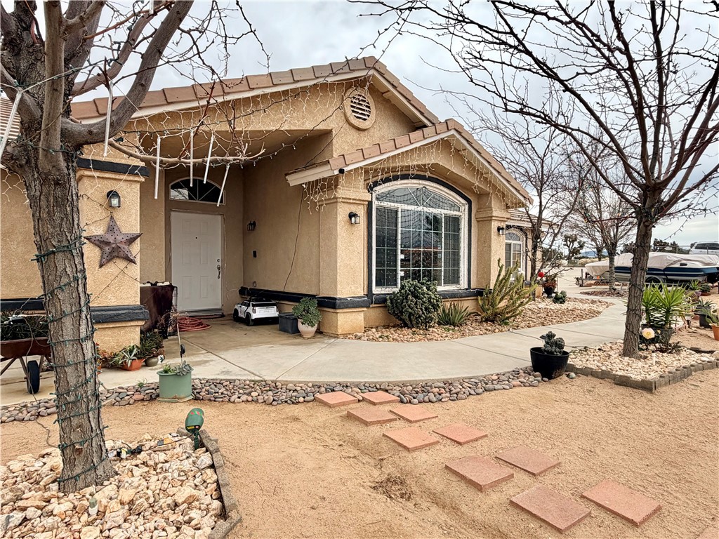 7915 Outpost Road Oak Hills, CA 92344 - Photo 21 of 54 a view of a white house with a outdoor space covered with snow in the background