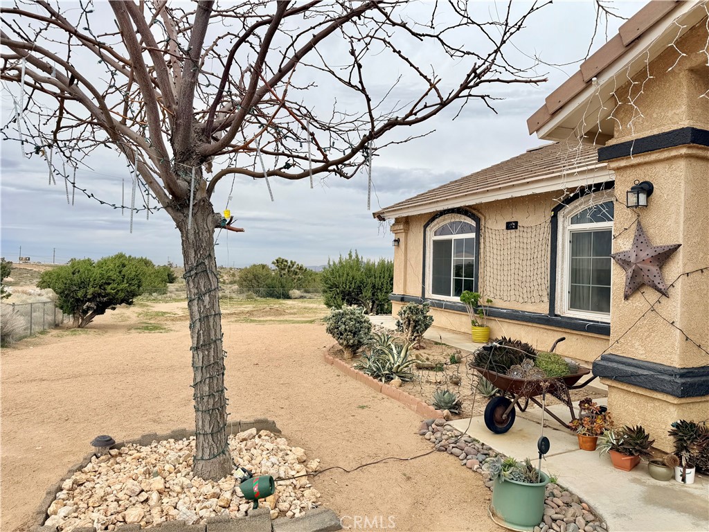 7915 Outpost Road Oak Hills, CA 92344 - Photo 29 of 54 a view of a patio with table and chairs under an umbrella
