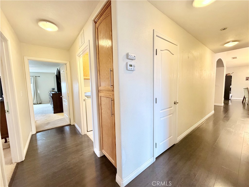 7915 Outpost Road Oak Hills, CA 92344 - Photo 32 of 54 a view of a hallway with wooden floor