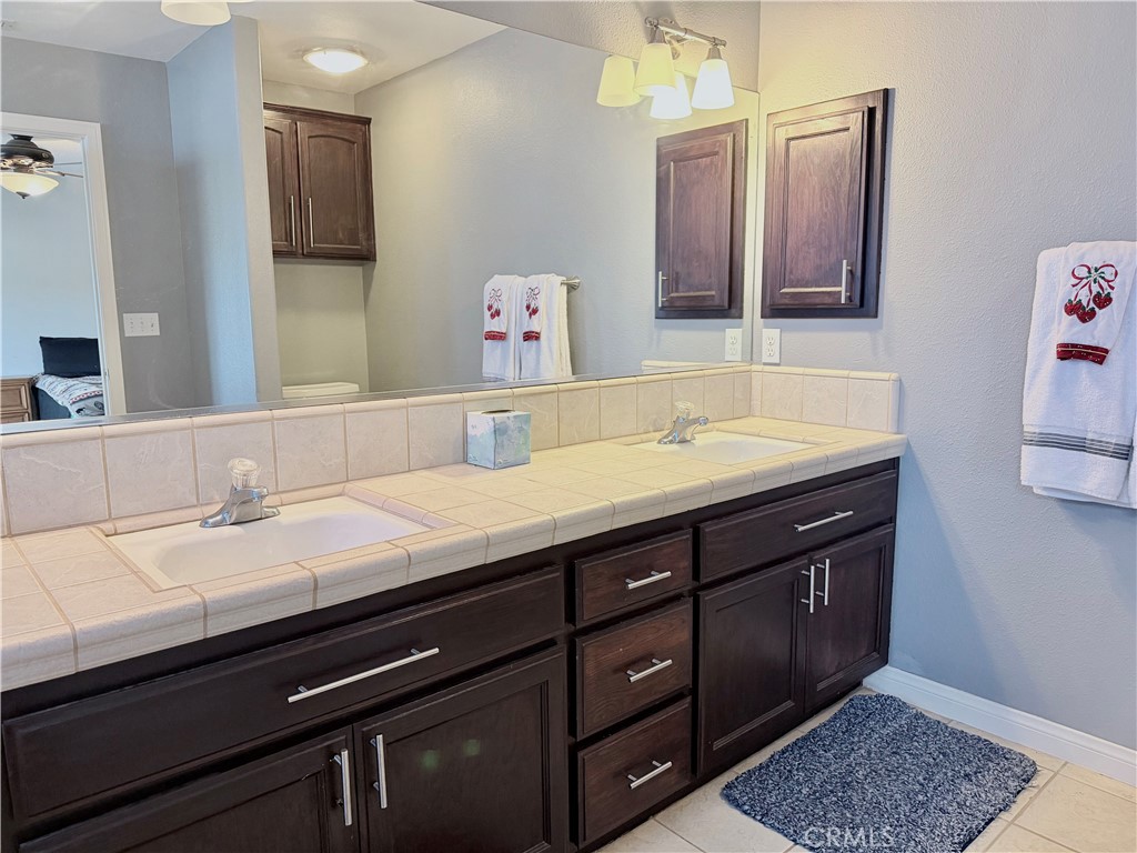 7915 Outpost Road Oak Hills, CA 92344 - Photo 35 of 54 a bathroom with a sink and a mirror