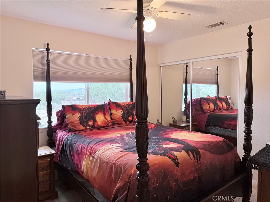 7915 Outpost Road Oak Hills, CA 92344 - Photo 43 of 54 a bedroom with a large bed and a window