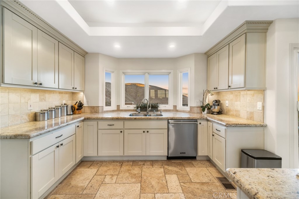 81 Marbella San Clemente, CA 92673 - Photo 20 of 65 a kitchen with a sink dishwasher a stove and white cabinets