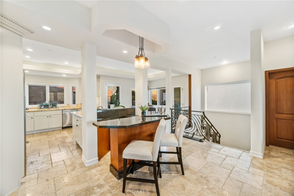 81 Marbella San Clemente, CA 92673 - Photo 26 of 65 a dining hall with stainless steel appliances kitchen island granite countertop a dining table chairs and a refrigerator
