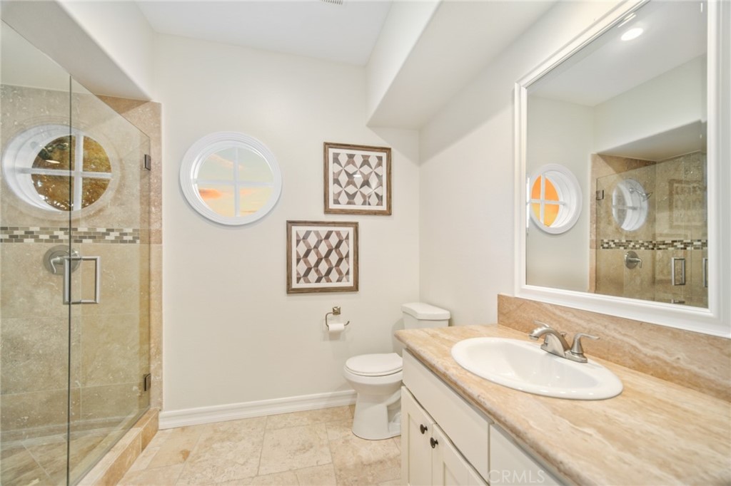 81 Marbella San Clemente, CA 92673 - Photo 42 of 65 a bathroom with a granite countertop sink toilet and a mirror