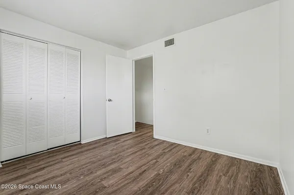 a view of an empty room with wooden floor