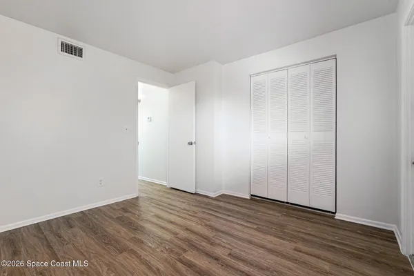 a view of an empty room with wooden floor