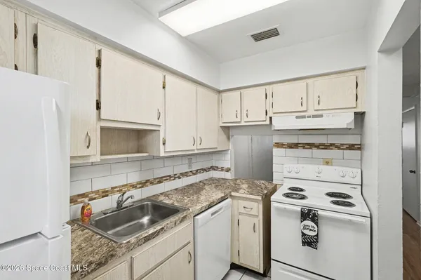 a kitchen with white cabinets sink and stainless steel appliances