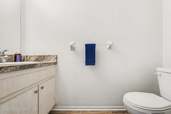 a bathroom with a granite countertop toilet and a sink