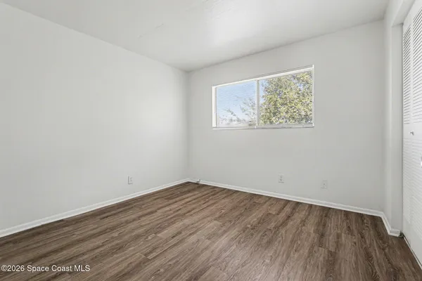 a view of a room with wooden floor and window
