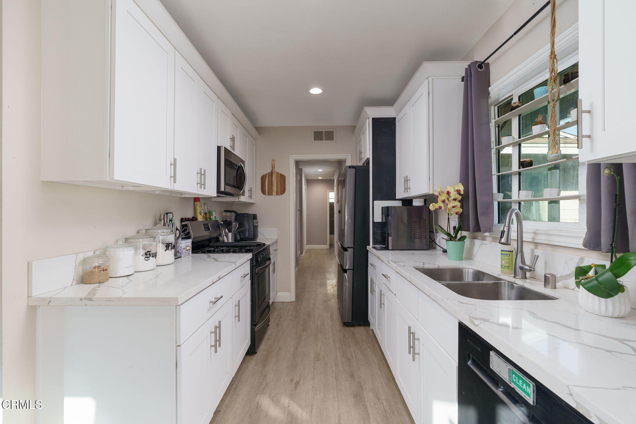 3651 South E Street Oxnard, CA 93033 - Photo 11 of 31 a kitchen with stainless steel appliances a sink stove refrigerator and cabinets