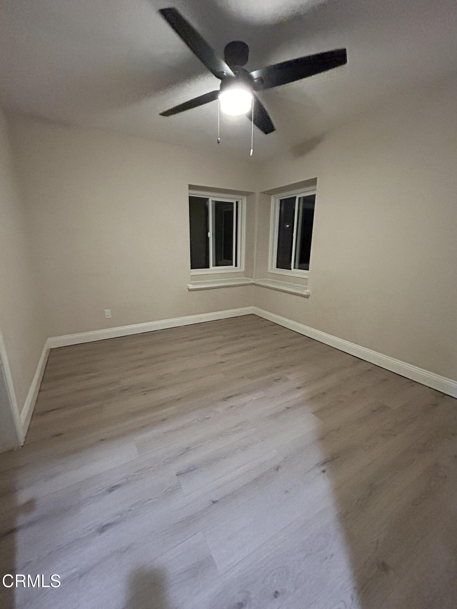 3651 South E Street Oxnard, CA 93033 - Photo 29 of 31 a view of an empty room with wooden floor and a ceiling fan