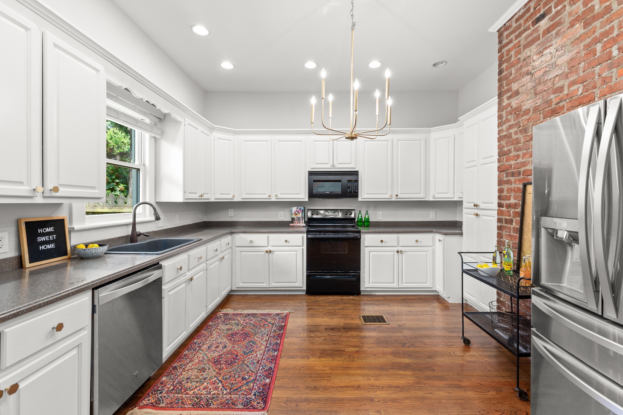 912 South Douglas Avenue Nashville, TN 37204 - Photo 12 of 34 a kitchen with stainless steel appliances granite countertop a refrigerator sink and white cabinets