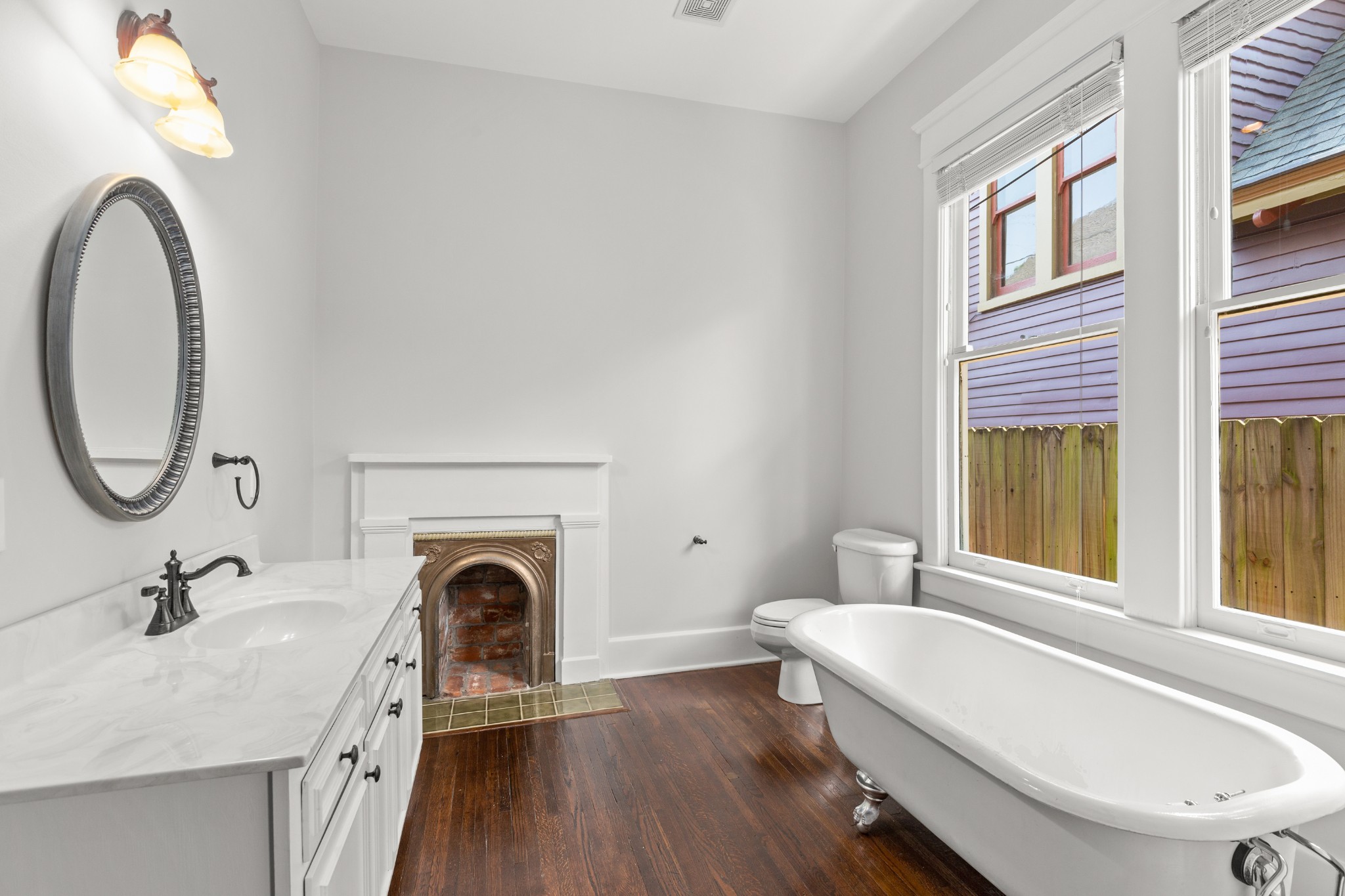 912 South Douglas Avenue Nashville, TN 37204 - Photo 19 of 34 a bathroom with a granite countertop bathtub a sink a mirror and a window