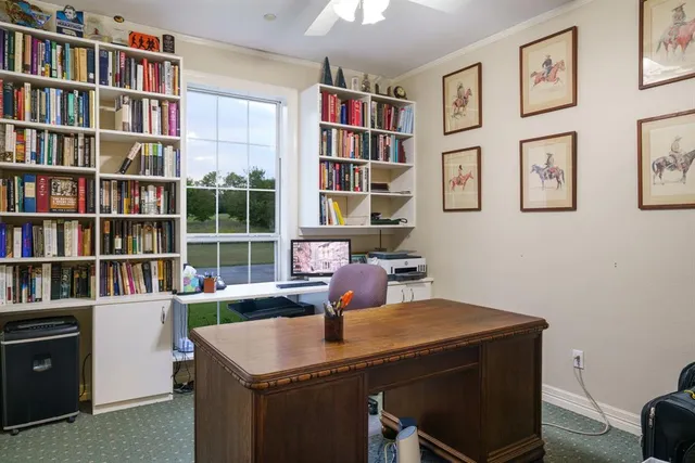 a view of a workspace with furniture and a book shelf