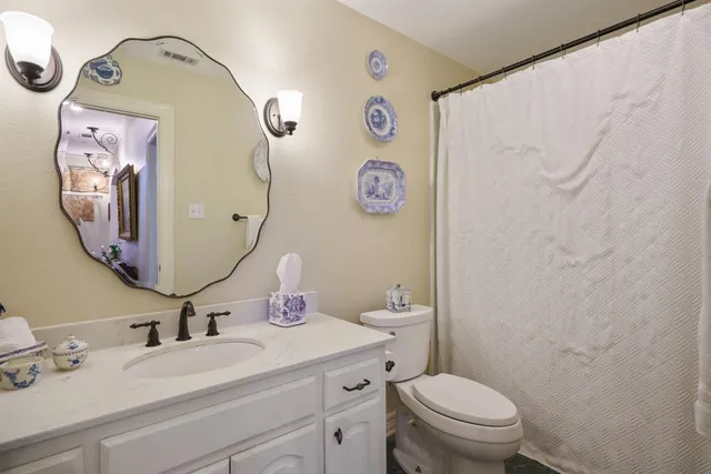 a bathroom with a toilet sink vanity and mirror