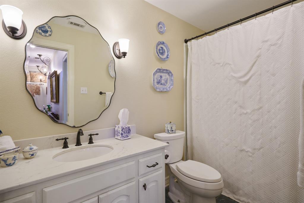 636 East Tripp Road Sunnyvale, TX 75182 - Photo 20 of 40 a bathroom with a toilet sink vanity and mirror
