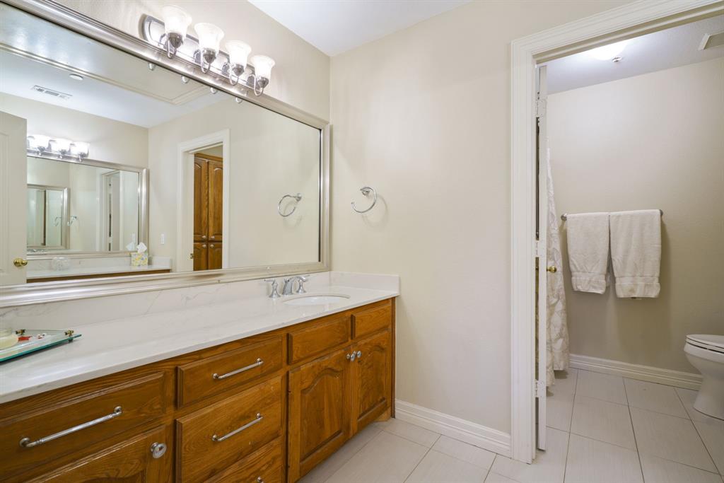 636 East Tripp Road Sunnyvale, TX 75182 - Photo 25 of 40 a spacious bathroom with a granite countertop sink mirror and toilet