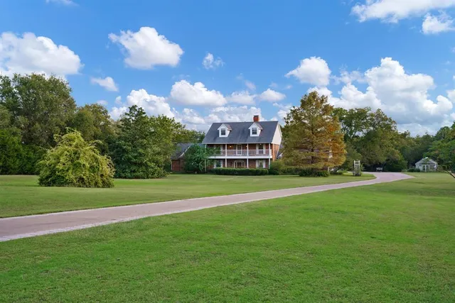 an aerial view of a house with a yard and lake view