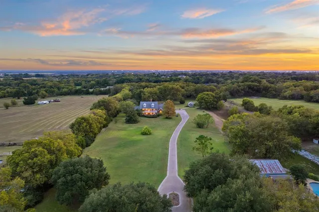 an aerial view of residential houses with outdoor space and lake view