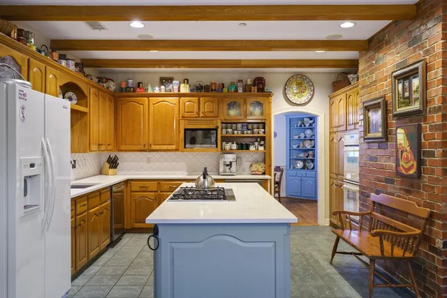 a utility room with stainless steel appliances kitchen island granite countertop a sink and cabinets