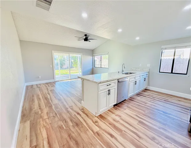 a large kitchen with stainless steel appliances granite countertop a lot of counter space and wooden floors